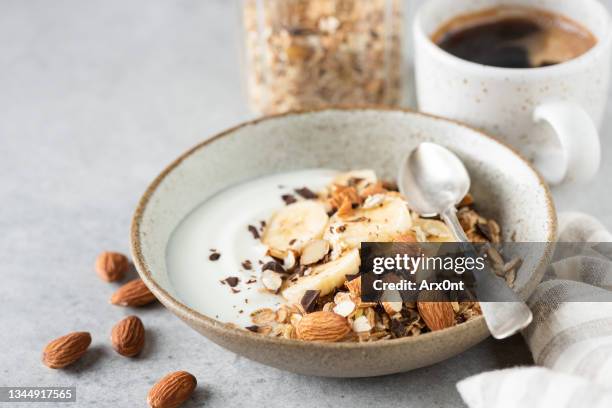 yogurt with granola, banana and almonds - granola stockfoto's en -beelden