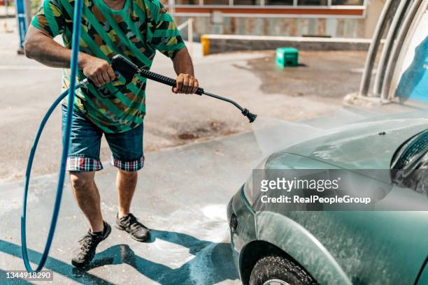 mann wäscht sein auto im freien - hochglanz stock-fotos und bilder