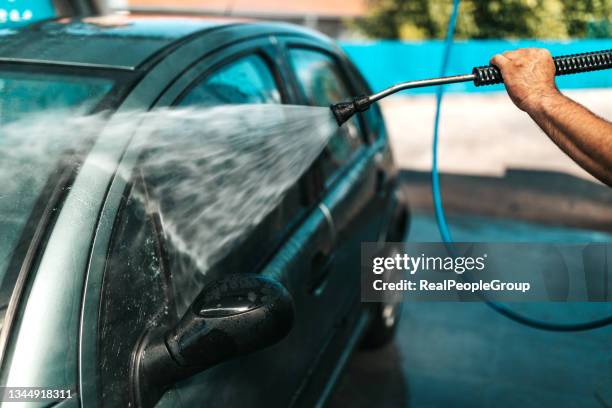 car washing. cleaning car using high pressure water. - mutterbricka bildbanksfoton och bilder