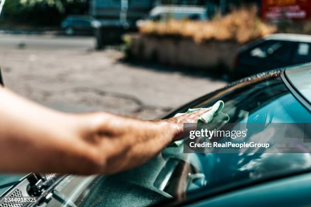 hombre maduro lavando el parabrisas del coche - abrillantar fotografías e imágenes de stock