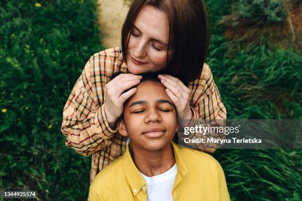 a white-skinned mother with a dark-skinned daughter is having fun. - babysitters club stock pictures, royalty-free photos & images