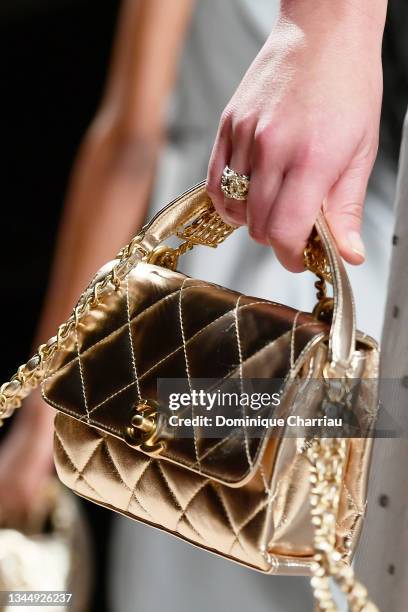 A model wearing a bag walks the runway during the Chanel