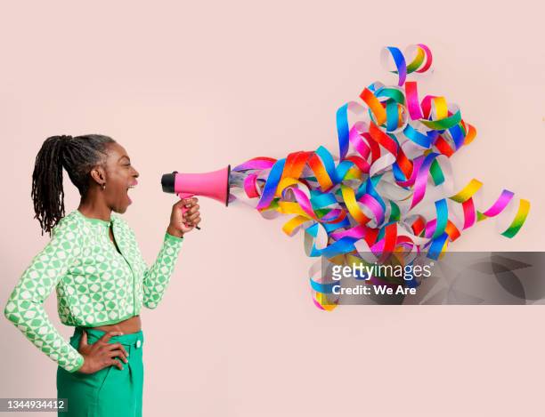 woman with megaphone and streamers - multi coloured megaphone stock pictures, royalty-free photos & images