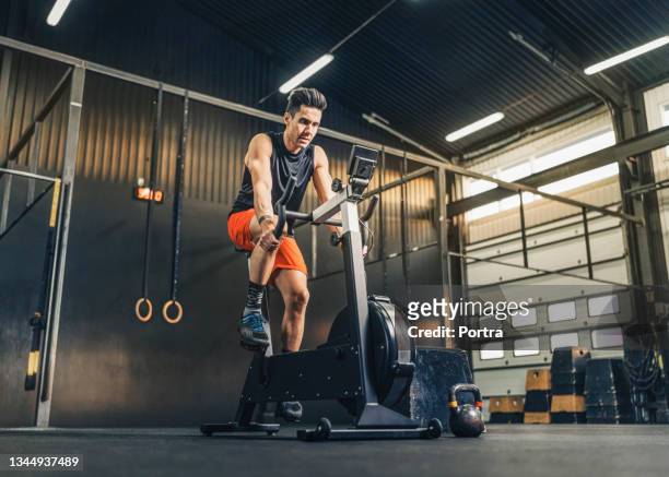 male athlete exercising on bike in gym - kardiovaskulär träning bildbanksfoton och bilder