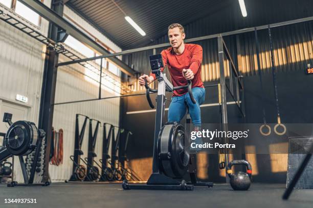 male athlete on exercise bike in health club - cycling gym stock pictures, royalty-free photos & images