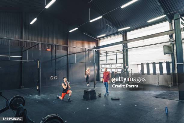 male and female athletes cross training in gym - weightlifting room stock pictures, royalty-free photos & images