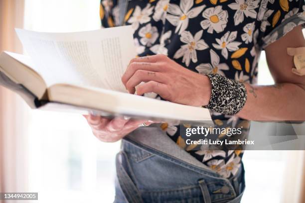 non-binary person reading a book - una palabra fotografías e imágenes de stock