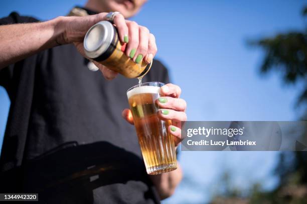 non-binary person pouring a glass of beer - beer pour stock pictures, royalty-free photos & images