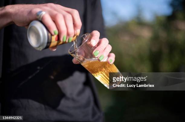 non-binary person pouring a glass of beer - beer pour stock-fotos und bilder