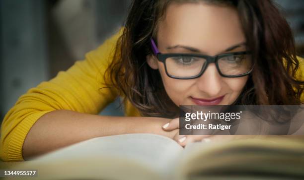woman in yellow, lying down, reading book - hands resting stock pictures, royalty-free photos & images