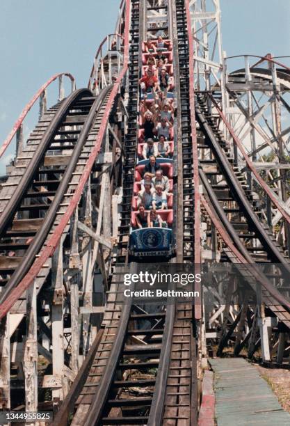 Riders on the Cyclone rollercoaster at Coney Island roll down a steep drop on the day the ride reopened, New York, US, 10th July 1986.