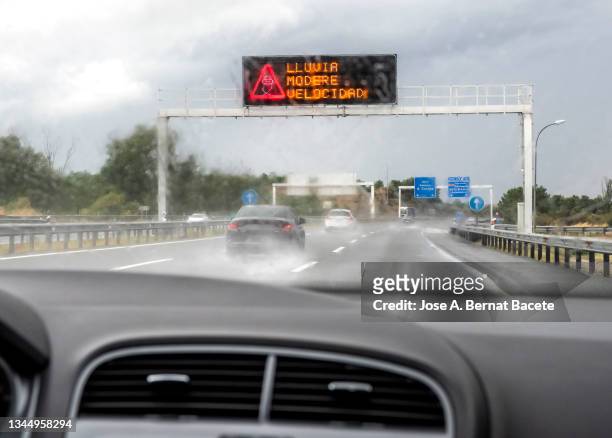 car point of view driving along rainy highway and light signal warning driving with caution in rain. - road signal ストックフォトと画像