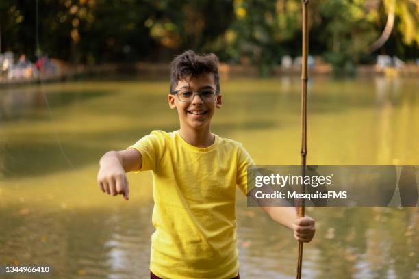 boy holding fishing rod and hook - boy river looking at camera stock pictures, royalty-free photos & images