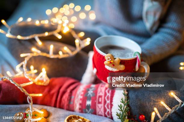 woman hands in cosy sweater holding a mug in a mug cosy - red stockings stock pictures, royalty-free photos & images