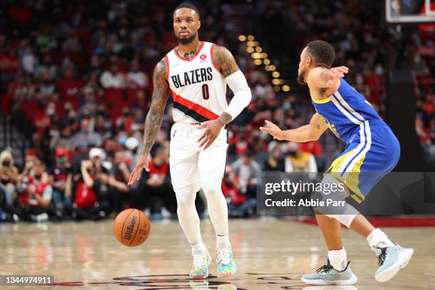 Damian Lillard of the Portland Trail Blazers handles the ball against Stephen Curry of the Golden State Warriors in the first quarter during the...