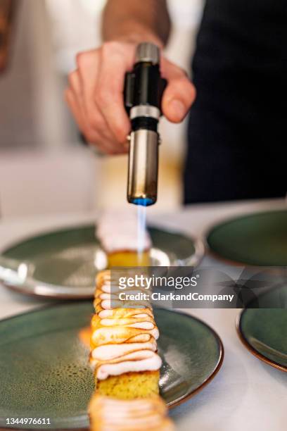 torching meringue cake topping - creme brulee stock pictures, royalty-free photos & images