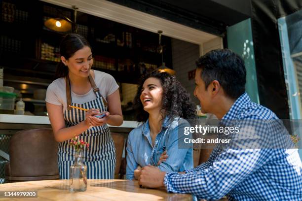 waitress taking the order of two happy customers at a restaurant - report fun stock pictures, royalty-free photos & images