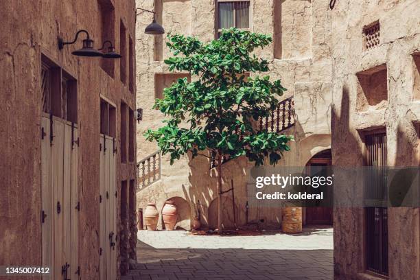 al fahidi historical neighborhood of dubai, alleywith lone tree - uae heritage stock pictures, royalty-free photos & images