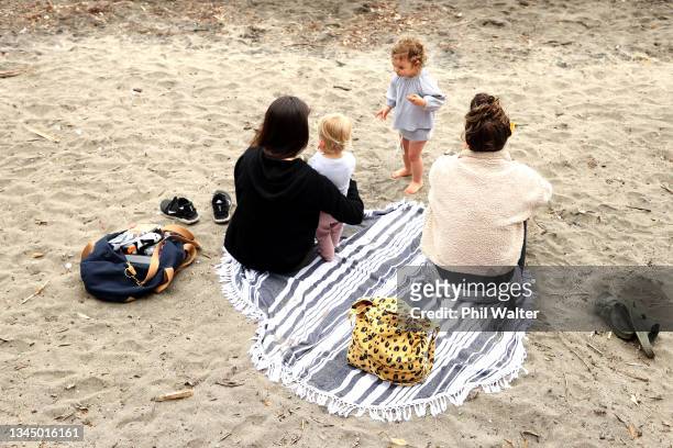 Families re-unite with a picnic at St Helliers beach on October 06, 2021 in Auckland, New Zealand. Alert Level 3 restrictions have eased slightly...
