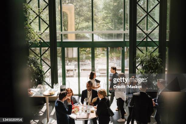 businesswomen and businessmen discussing together during meeting at convention center - social gathering stock-fotos und bilder