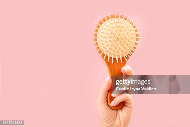 woman hands holding natural bamboo wooden comb brush. routine step for healthy skin and hair care. - bürsten stock-fotos und bilder