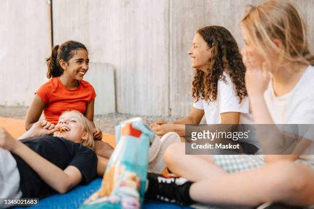 happy multi-ethnic girls having snack at basketball court - food court stock-fotos und bilder