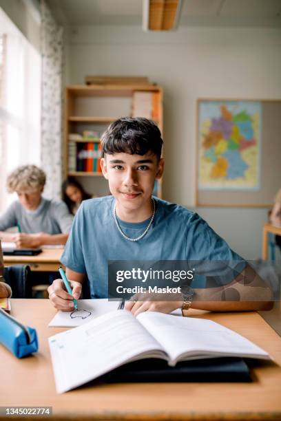 portrait of teenage boy drawing on book in classroom - sweden school stock pictures, royalty-free photos & images