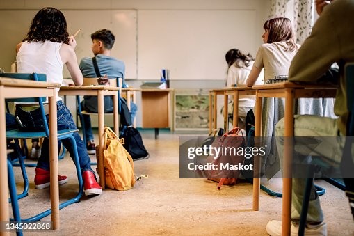 Multiracial group of students sitting at desk in classroom Multiracial group of students sitting at desk in classroom