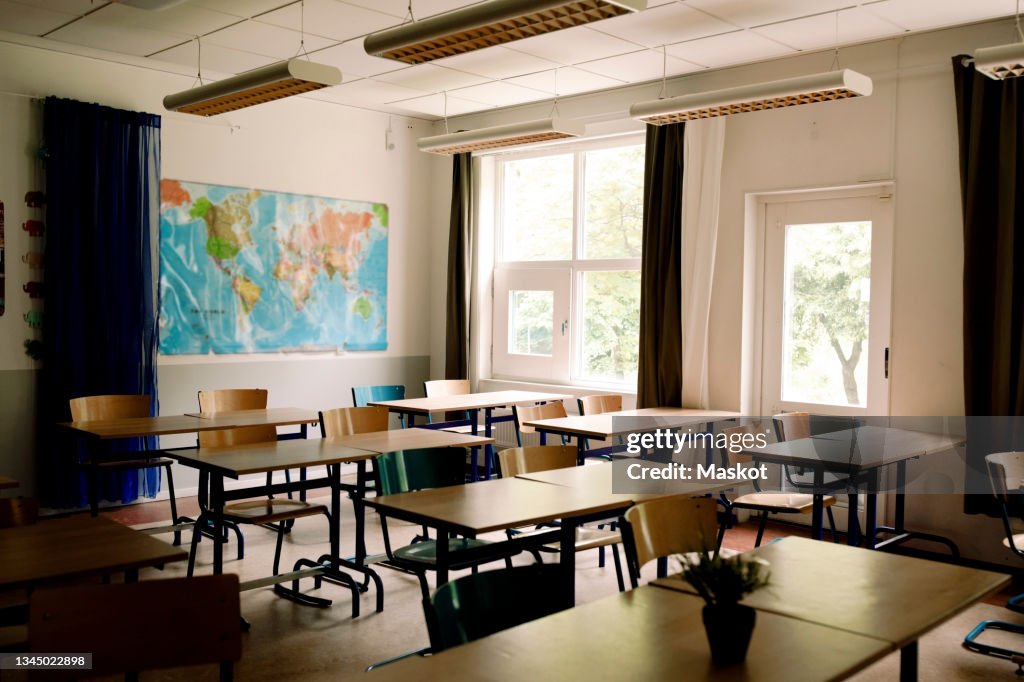 Desks and chairs arranged in classroom at high school