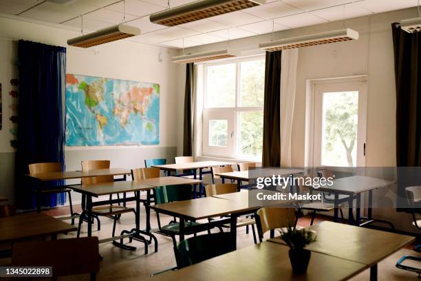 desks and chairs arranged in classroom at high school - exilio fotografías e imágenes de stock