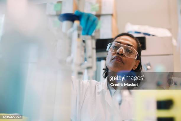 female healthcare worker doing research in laboratory - microbiologist fotografías e imágenes de stock