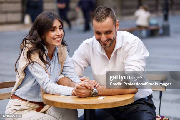 young woman is enjoying time together in romantic meal in modern restaurant with her handsome boyfriend. - table for two stock pictures, royalty-free photos & images