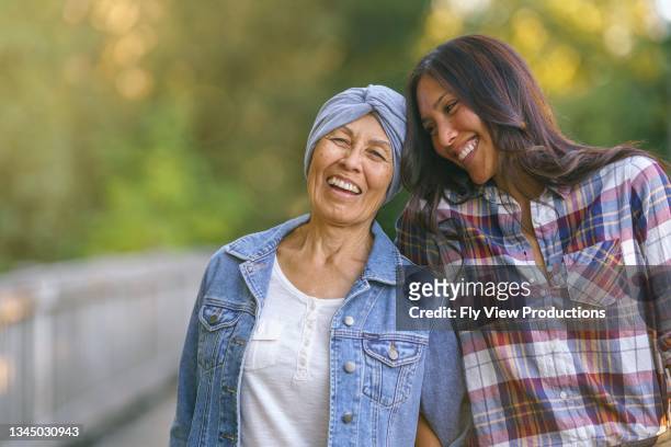 happy senior woman with cancer laughing with daughter - cancer support stock pictures, royalty-free photos & images
