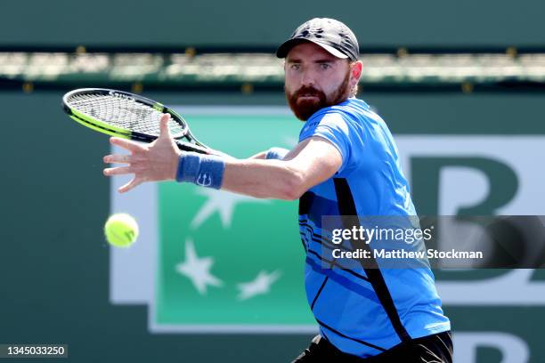 Bjorn Fratangelo returns a shot to Mikael Torpegaard of Denmark during qualifying for the BNP Paribas Open at the Indian Wells Tennis Garden on...