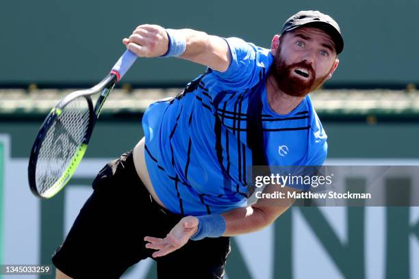 Bjorn Fratangelo serves to Mikael Torpegaard of Denmark during qualifying for the BNP Paribas Open at the Indian Wells Tennis Garden on October 05,...