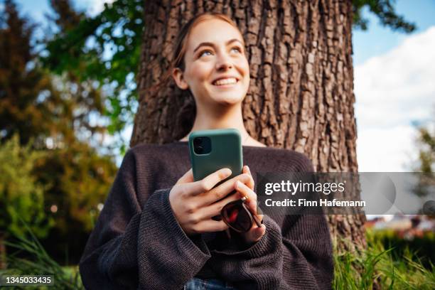 happy smiling young woman on mobile phone - tree smartphone stock pictures, royalty-free photos & images