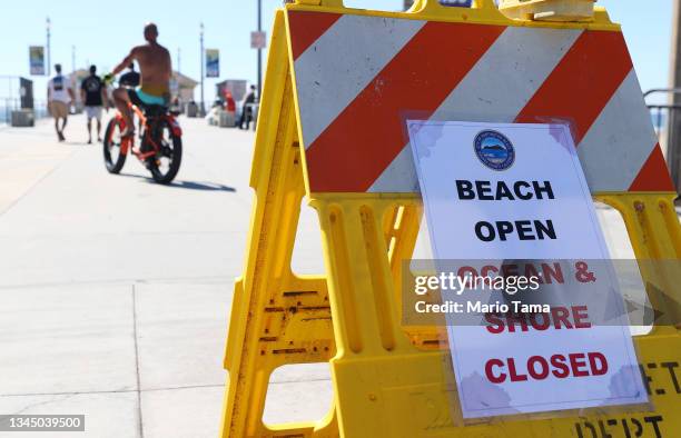 Sign is posted on Huntington Beach Pier reading 'Ocean & Shore Closed' after a 126,000-gallon oil spill from an offshore oil platform on October 5,...