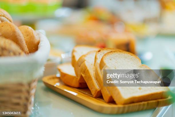 close up a loaf of homemade sourdough bread on a chopping board on counter kitchen marble top home interior background - white bread stockfoto's en -beelden