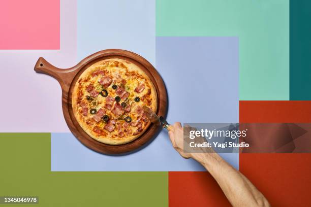 pizza and pizza cutter with colorful background - pizzaskärare bildbanksfoton och bilder