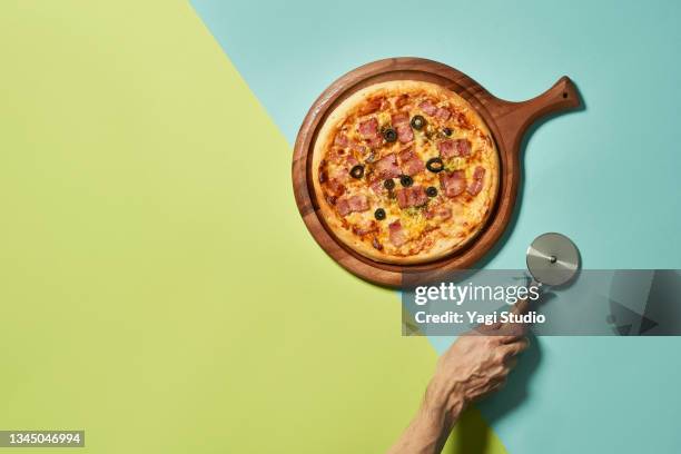 pizza and pizza cutter with colorful background - ピザカッター ストックフォトと画像