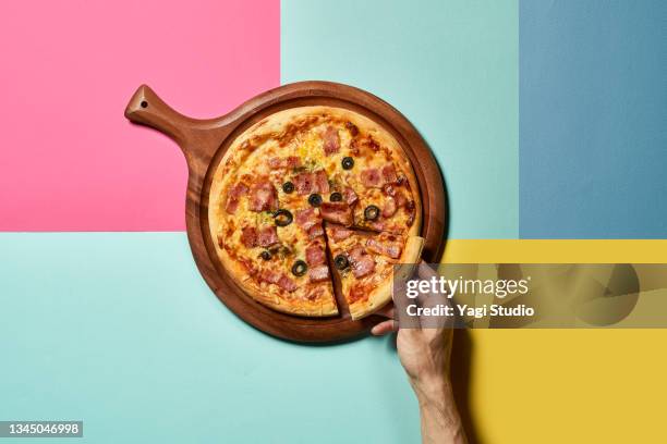 pizza and hand with colorful background - pizza fotografías e imágenes de stock