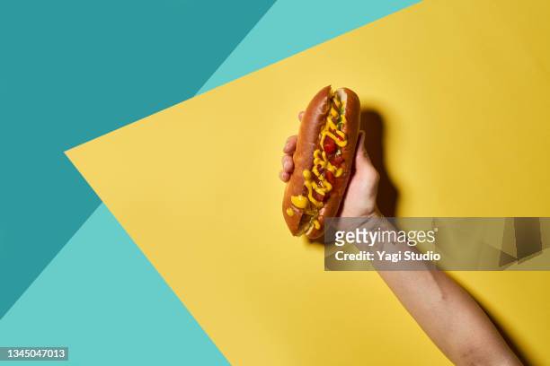 hotdog on a colorful background. - food on coloured background stock pictures, royalty-free photos & images