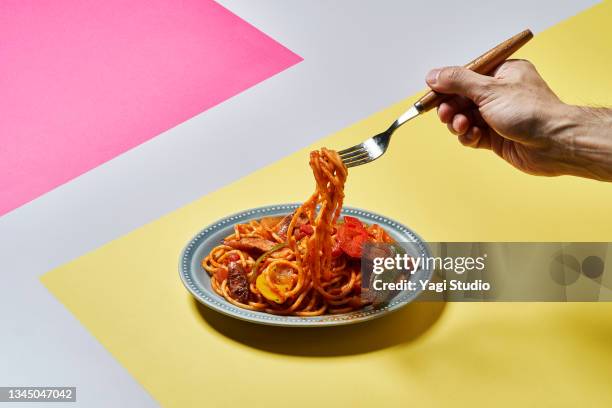 neapolitan spaghetti with hand holding a fork - fork stock pictures, royalty-free photos & images