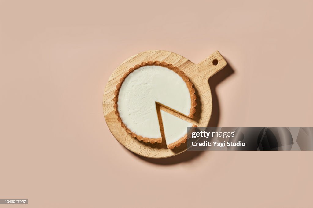 Overhead shot of rare cheese cake on a round wood board