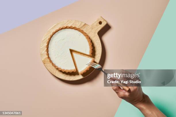 overhead shot of rare cheese cake on a round wood board - cake stock-fotos und bilder