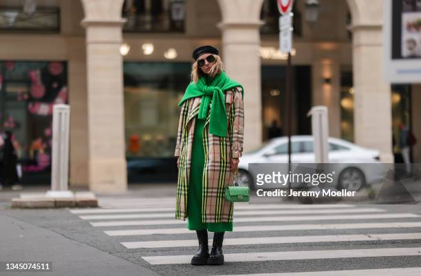 Karin Teigl wearing a Burberry coat, gucci shades and a chanel bag on October 02, 2021 in Paris, France.