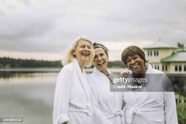 portrait of cheerful senior women in bathrobe during holiday - 3 men standing outside stockfoto's en -beelden