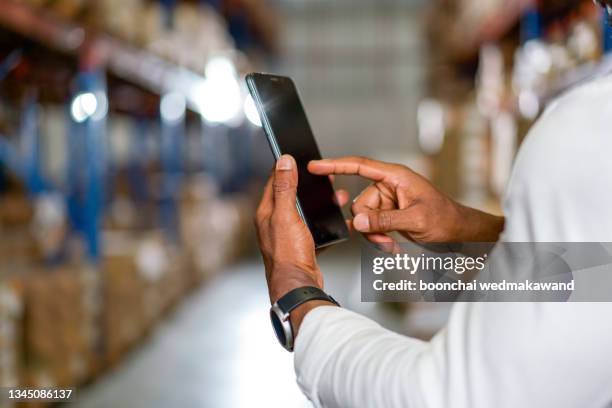 warehouse worker in uniform is inspecting shipment for delivering to customers. - call centre digital stock-fotos und bilder