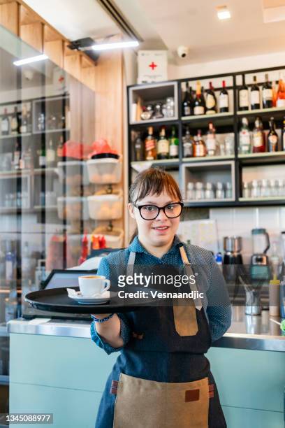 junge frau mit down-syndrom bei der arbeit im café - women serving coffee stock-fotos und bilder