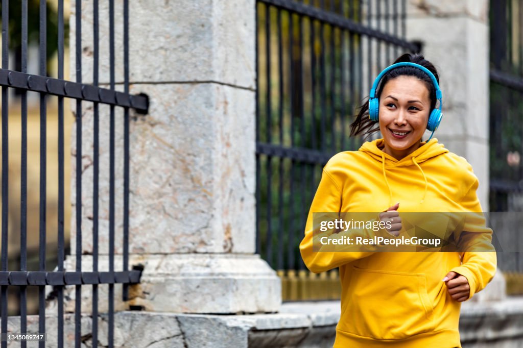 Adatta donna adulta media che corre in città.